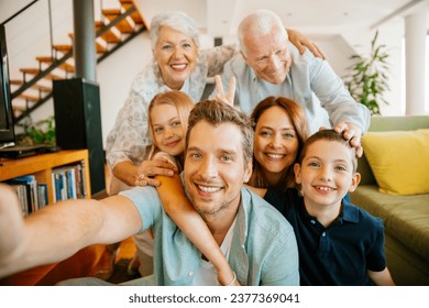 Portrait of a happy multigenerational taking a selfie in the living room - Powered by Shutterstock