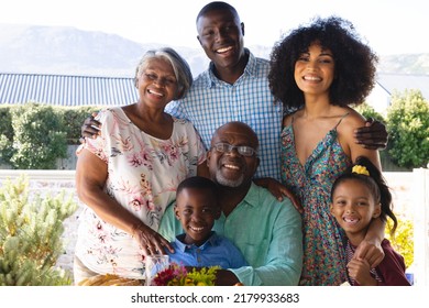 Portrait of happy multiracial multigeneration family enjoying leisure time together in yard. Unaltered, togetherness, love, childhood, lifestyle and retirement concept. - Powered by Shutterstock