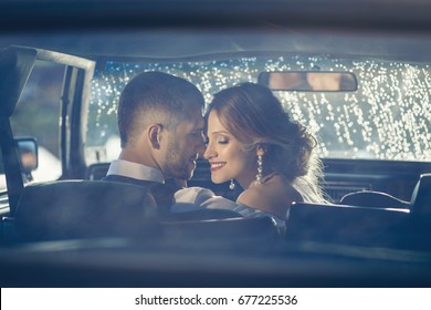 Portrait Of Happy Newlywed Couple In Car On Sunset After Rain