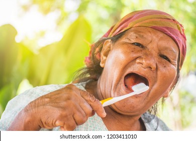 Portrait Of A Happy Old Woman Brushing Her Teeth.