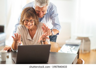 Portrait Happy Older Couple Looking At Laptop Screen During Video Call 