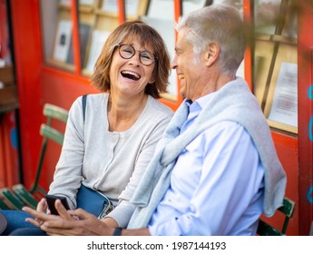 Portrait Happy Older Couple Sitting Outside Laughing