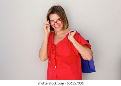 Portrait Of Happy Older Woman With Glasses And Shopping Bags