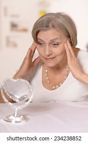 Portrait Of A Happy Older Woman At Home Looking In The Mirror