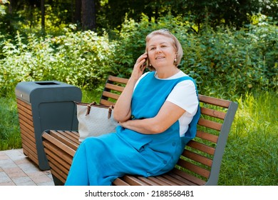 Portrait Happy Older Woman Sitting On Park Bench Talking With Cellphone