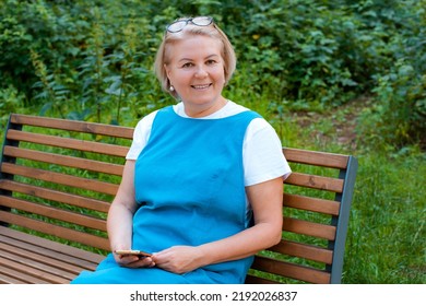 Portrait Happy Older Woman Sitting On Park Bench Talking With Cellphone