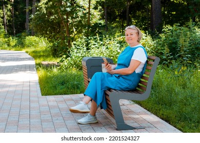 Portrait Happy Older Woman Sitting On Park Bench Talking With Cellphone