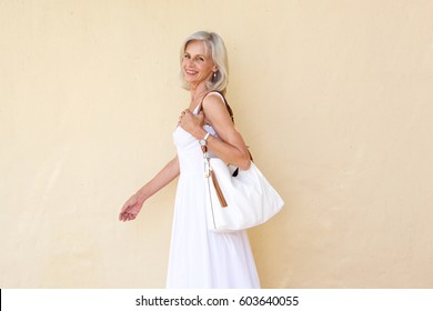 Portrait Of Happy Older Woman In Summer Dress Walking With Purse