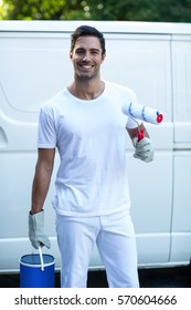Portrait of happy painter with equipment standing against van - Shutterstock ID 570604666