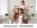 Portrait of happy parents with daughter at home. The family shows love and affection, bonding in a warm and loving environment, strengthening relationship as they share quality time.