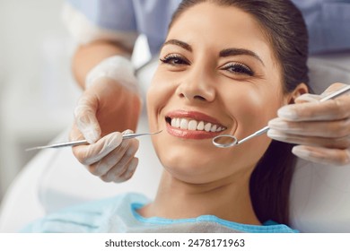 Portrait of a happy patient during a visit to the dentist. The doctor is checking teeth using a dental instrument, ensuring proper oral care and thorough examination in the dentistry clinic.