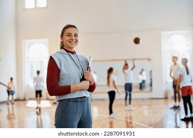 Portrait of happy physical education teacher during a class at school gym.