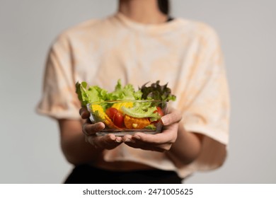 Portrait of a happy playful Asian girl eating fresh salad from a glass bowl after workout at home. Young lady Enjoying Healthy Nutrition And Organic Food, Having Vegetarian Meal