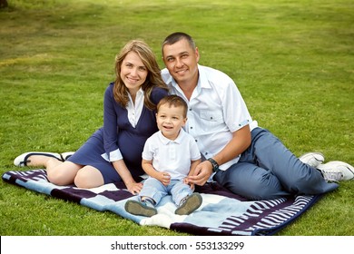 Portrait Of A Happy Playing Family Outdoors. Young Parents With Son In The Summer. Mom, Dad And Child