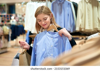 Portrait Of Happy Positive Cheerful Teen Teenager Girl, Young Beautiful Pretty Woman Is Smiling In Mall, Shopping With Bags Choosing Clothes In Boutique. Shopaholic Lady Customer Buying In Shop, Store