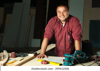 Portrait of happy professional carpenter at his work place.