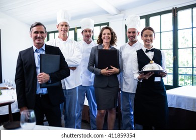 Portrait of happy restaurant team standing together in restaurant