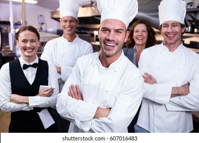 Portrait Of Happy Restaurant Team Standing Together With Arms Crossed In Commercial Kitchen