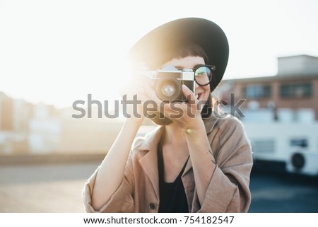 junge Frau beim Fotografieren mit Retro-Kamera auf Roadtrip