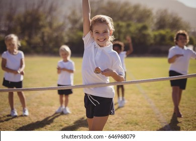 Portrait of happy schoolgirl wining egg and spoon race in park - Powered by Shutterstock