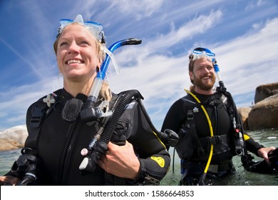 Portrait Of Happy Scuba Diver Woman And Man Walking Out Of Ocean After Dive