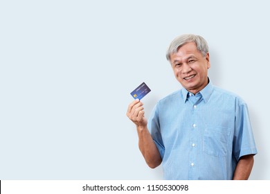 Portrait Of Happy Senior Asian Man Holding Credit Card And Showing On Hand Smiling And Looking At Camera On Isolated Background Feeling Positive And Enjoy. Older Lifestyle Concept With Clipping Path.