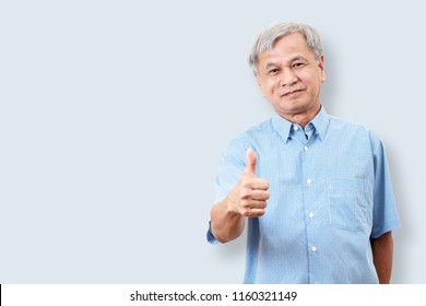 Portrait Of Happy Senior Asian Man Gesture Hand Showing Thumb Up Or Good Sign And Looking At Camera On Isolated Background Feeling Positive And Satisfaction. Older Mature Male Lifestyle Concept.