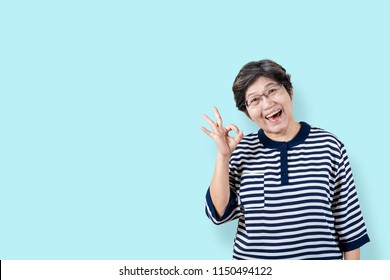 Portrait Of Happy Senior Asian Woman Gesture Or Showing Hand Ok And Looking At Camera On Isolated Background Feeling Positive Enjoy And Satisfaction. Older Female Lifestyle Concept With Clipping Path.