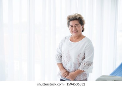 Portrait of happy senior Asian woman smiling in hospital room. The smiling Asian senior woman has happy life as she is healthy & beautiful. Vitality & healthy old Asian woman concept. 60s citizen.