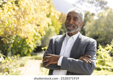 Portrait of happy senior biracial man smiling in sunny garden at home, copy space. Happiness, nature, wellbeing, summer and senior lifestyle, unaltered. - Powered by Shutterstock