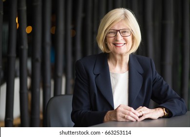 Portrait Of Happy Senior Business Woman At Table