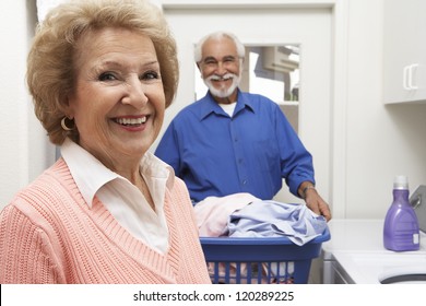 Portrait Of A Happy Senior Couple In Bathroom Washing Clothes