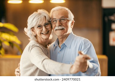 Portrait of a happy senior couple dancing and having fun at home. - Powered by Shutterstock