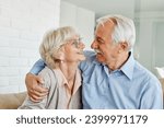 Portrait of a happy senior couple embracing hugging and having fun at home