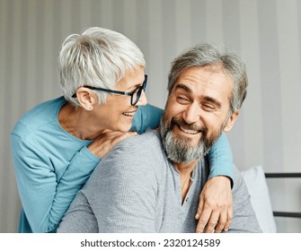 Portrait of a happy senior couple embracing each other on bed, elderly couple at home - Powered by Shutterstock