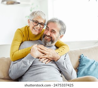 Portrait of a happy senior couple embracing hugging and having fun at home - Powered by Shutterstock