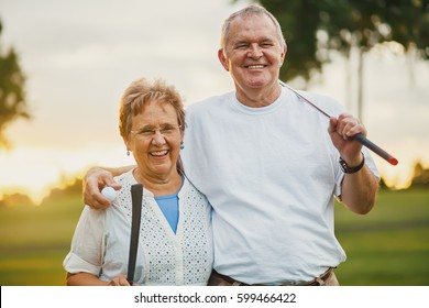 portrait of happy senior couple enjoying active lifestyle playing golf - Powered by Shutterstock