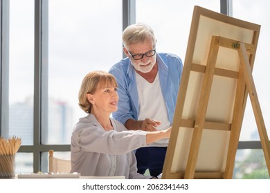 Portrait Of Happy Senior Couple Painting On A Canvas In Living Room, Older Man And Woman Drawing Together On A Canvas, Happy Retirement Concepts