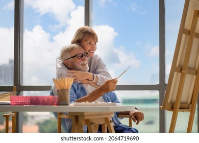 Portrait Of Happy Senior Couple Painting On A Canvas In Living Room, Older Man And Woman Drawing Together On A Canvas, Happy Retirement Concepts