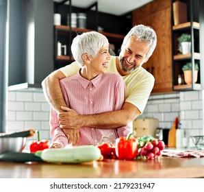Portrait of happy senior couple prepering meal in kitchen