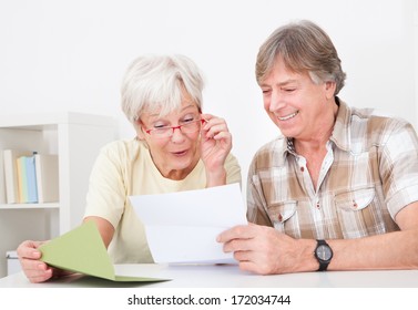 Portrait Of Happy Senior Couple Reading Letter Together