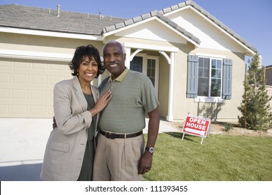 Portrait Of Happy Senior Couple Standing In Front Of House