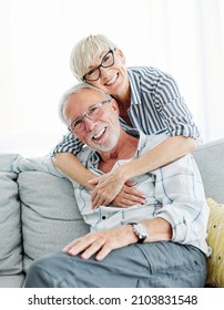 Portrait Of A Happy Senior Couple Taking A Selfie Embracing Hugging And Having Fun At Home