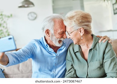 Portrait of a happy senior couple taking a selfie embracing hugging and having fun at home - Powered by Shutterstock