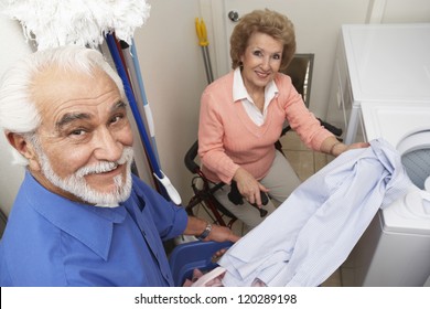 Portrait Of A Happy Senior Couple Washing Clothes In The Bathroom