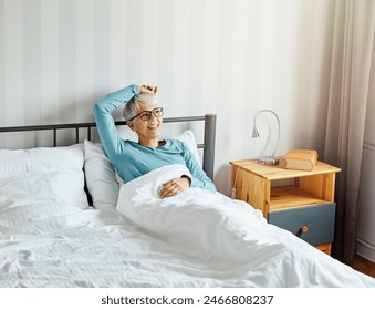 Portrait of a happy senior elderly woman relaxing in bed in the morning, a mature woman at home, bedding pillow and sheet - Powered by Shutterstock