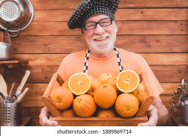 Portrait of happy senior man smiling and pleased with his orange crop showing to the camera the basket full of freshly picked oranges - Powered by Shutterstock