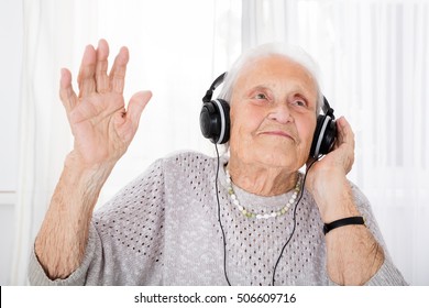 Portrait Of Happy Senior Woman Enjoying Music With Headphone At Home