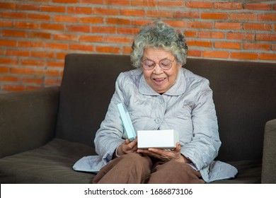 Portrait Of Happy Senior Woman Holding Gift Box,Senior Woman Opening Gift.