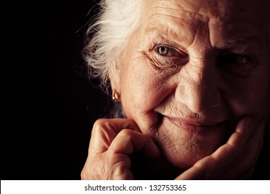 Portrait Of A Happy Senior Woman Smiling At The Camera. Over Black Background.